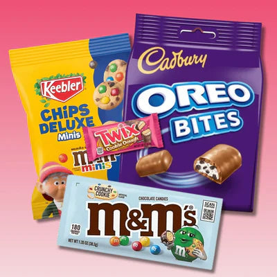 Assorted American candy including Keebler Chips Deluxe Minis, Oreo Bites, Twix, and M&M's on pink background