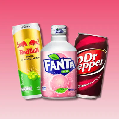 International soda cans Red Bull, Fanta, Dr Pepper on pink background