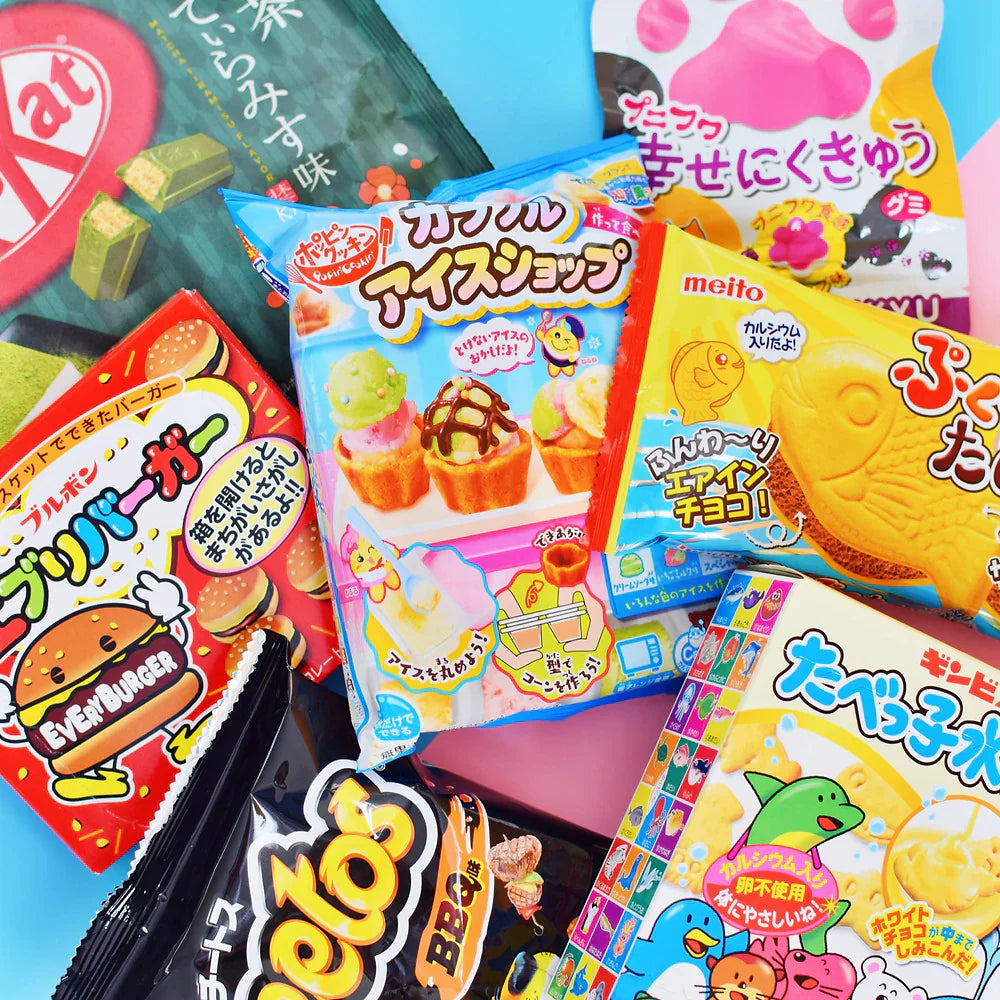 Assorted colorful Asian candy and snack packages on a pink and blue background